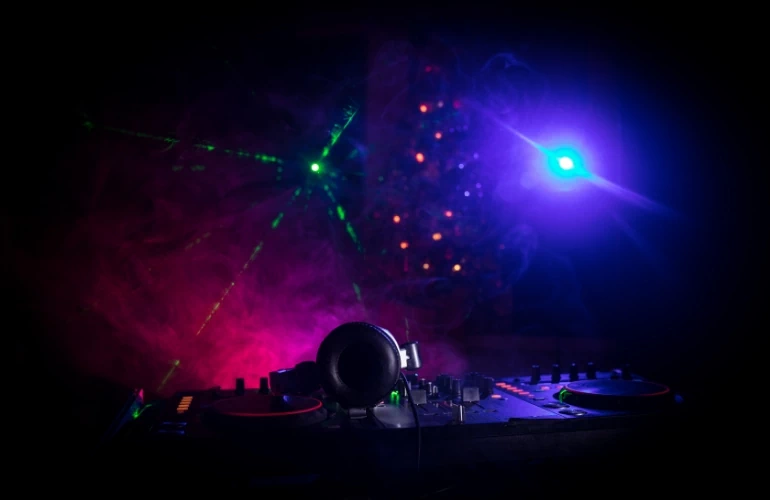 lasery i światła imprezowe ponad konsolą dj'a